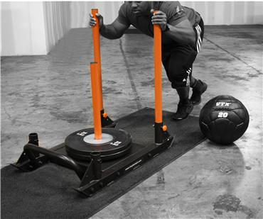 Person pushing a Troy VTX Push/Pull Sled &amp; Strap by Troy Barbell, ideal for acceleration training in the gym.